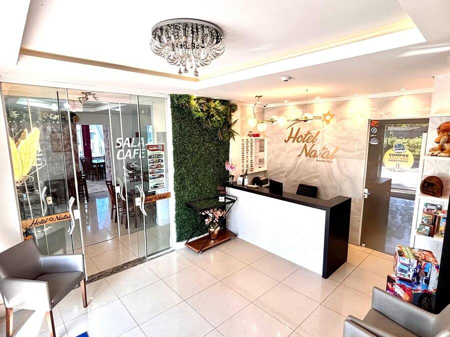 A hotel reception area with a modern design, including a reception desk, seating area, and a decorative wall.