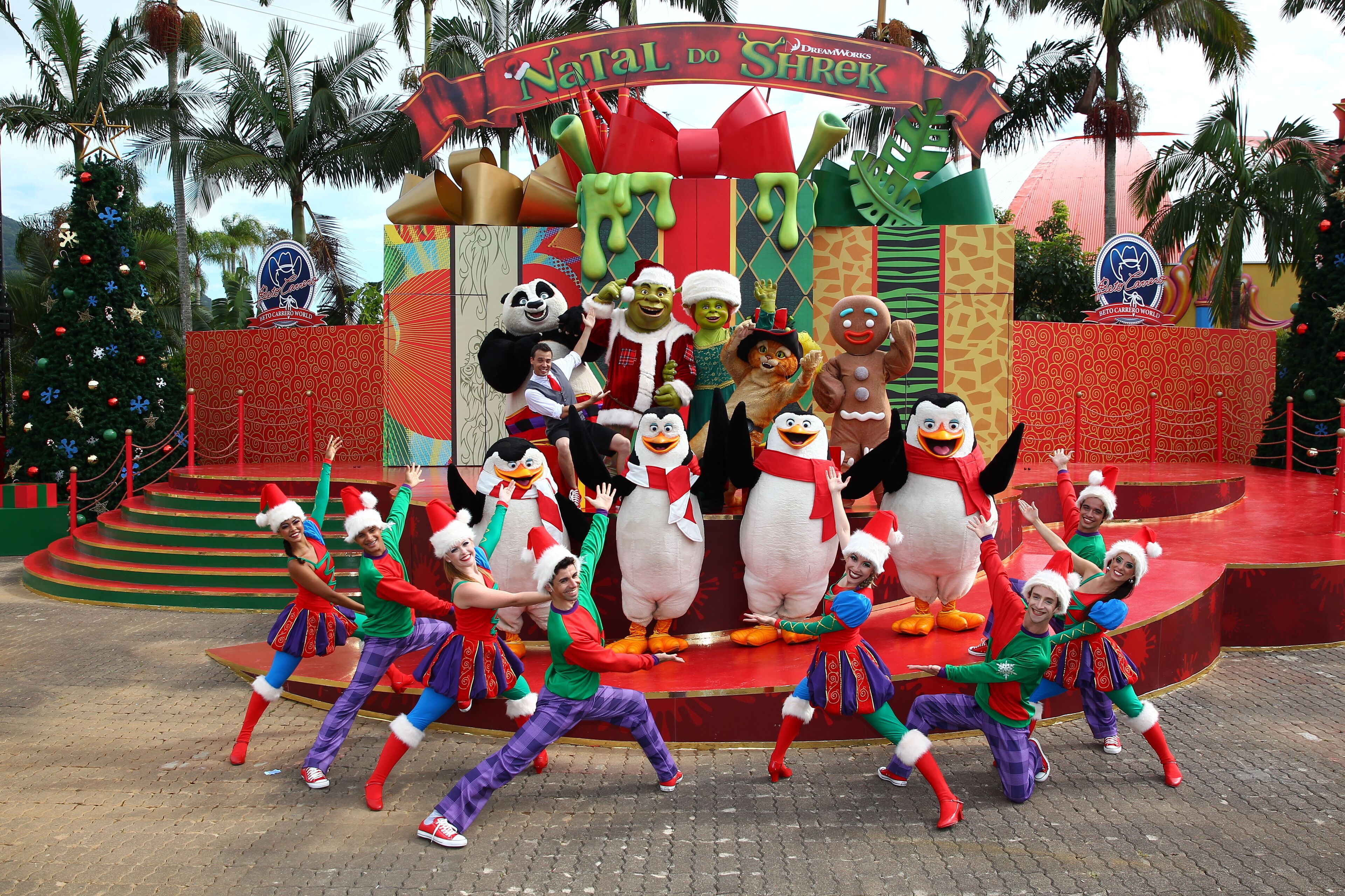 A festive stage with performers and large character mascots.