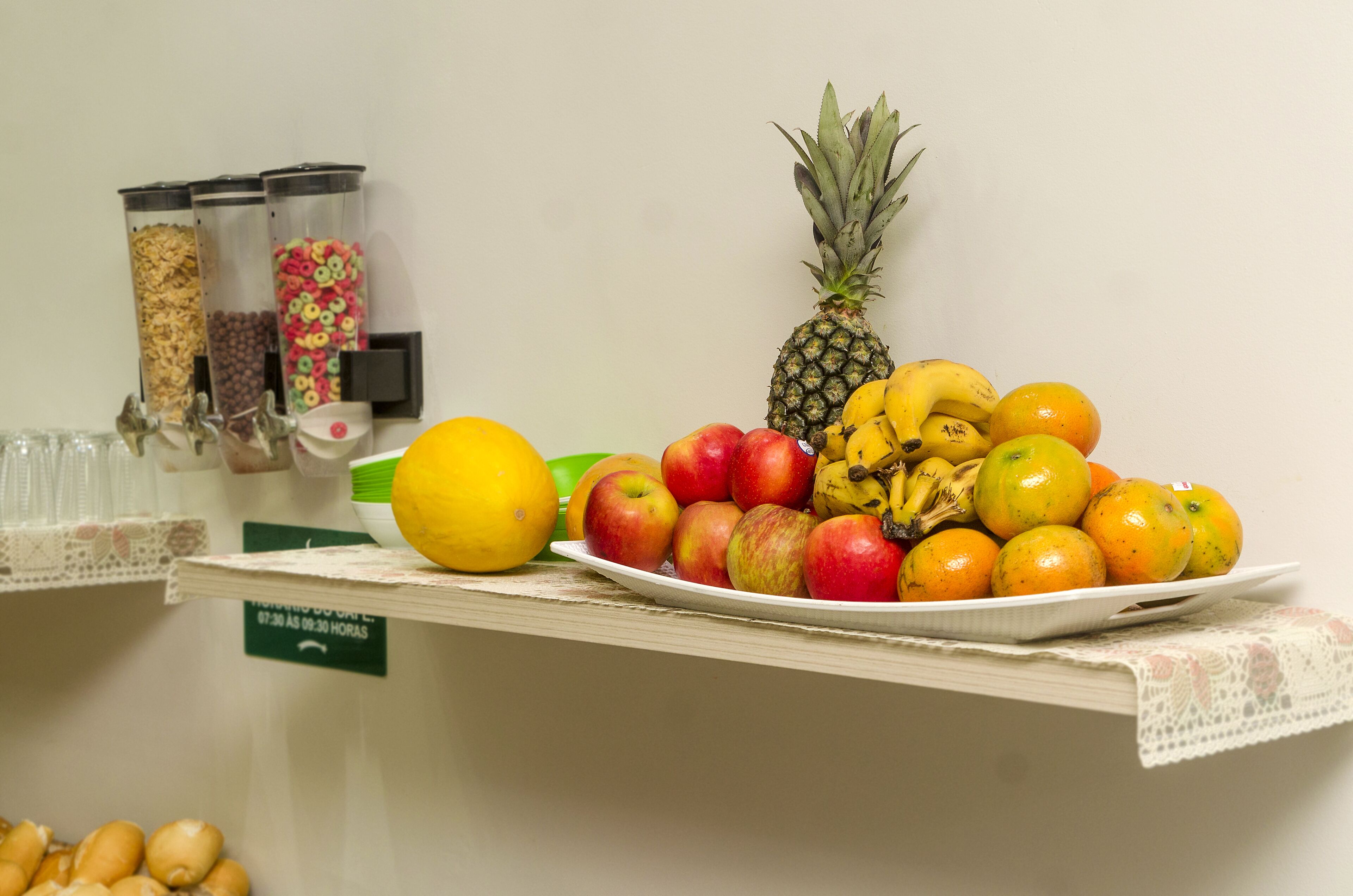 Een presentatie van fruit met een ananas, bananen, appels en sinaasappels op een tafel.