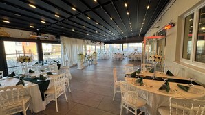 A spacious indoor dining area with multiple tables and chairs, a high ceiling with lighting, and large windows allowing natural light. - F Hotel 24h Check-In (Hoersching)