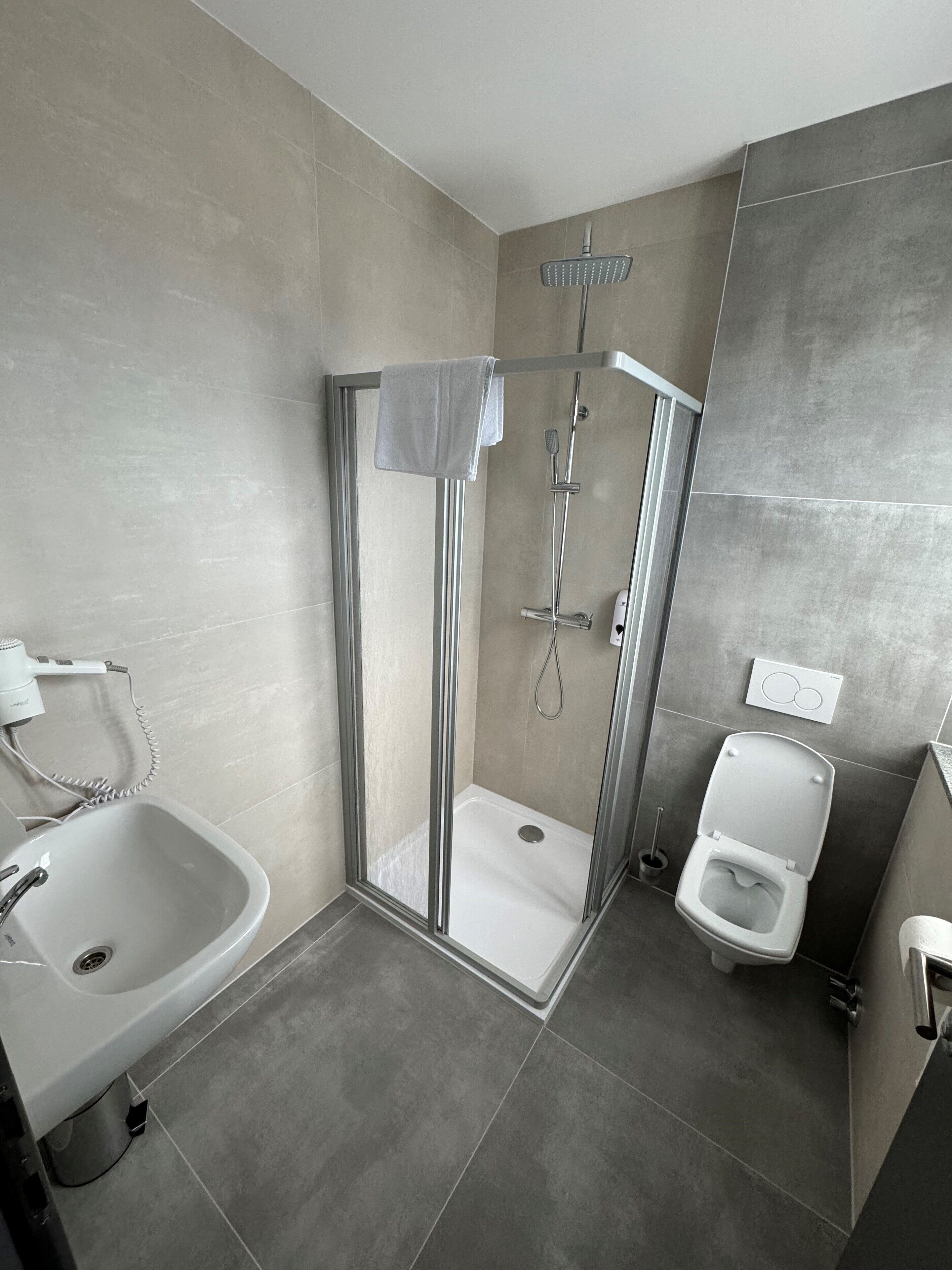 Une salle de bain moderne avec une douche à parois de verre, une baignoire sur pieds et des toilettes.