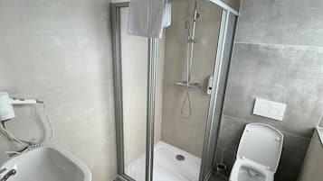 Une salle de bain moderne avec une douche à parois de verre, une baignoire sur pieds et des toilettes.