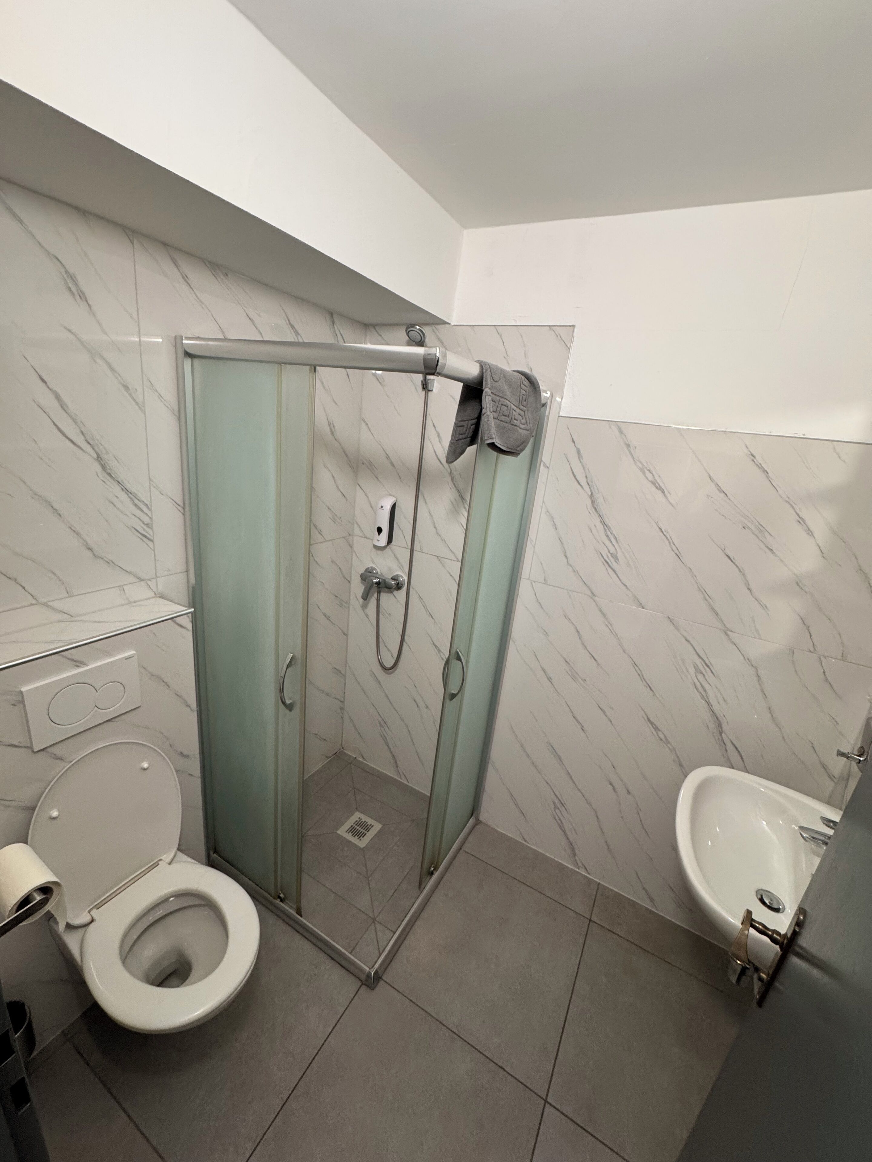 Un baño moderno con ducha de vidrio, inodoro y bidé.