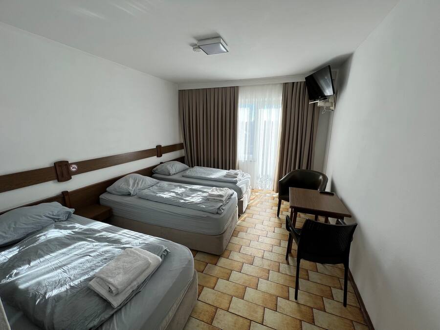 A hotel room with two beds, a desk, and a chair.