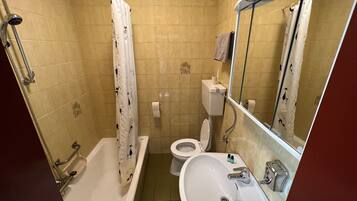 Ein Badezimmer mit Badewanne, Toilette, Waschbecken und Spiegel.