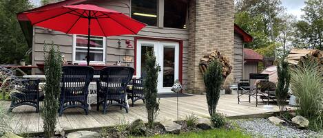 A patio area with outdoor seating and a red umbrella.