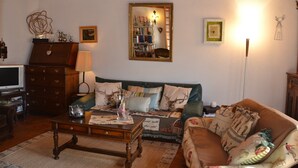 A cozy living room with a sofa, a coffee table, a television, and a wooden cabinet. - Outside : Apartment for 4-6 people, balcony with beautiful view -Inside : 65 sqm, living with , dine (St-Luc)