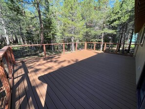 Surrounded by a serene forest, this cabin's deck offers a tranquil retreat.
