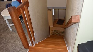 A wooden staircase with a carpeted landing and a white door at the top. - 5 BR Nags Head second row beach house  (Nags Head)