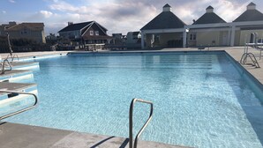 A swimming pool with steps and metal railings, surrounded by buildings with gabled roofs. - 5 BR Nags Head second row beach house  (Nags Head)