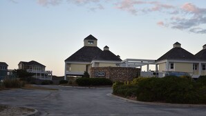 A residential area with houses, a stone wall, and a sign that reads "Vineyard Beach Club." - 5 BR Nags Head second row beach house  (Nags Head)
