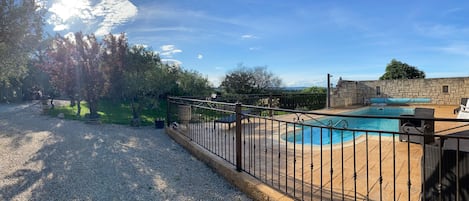 Una piscina al aire libre de temporada, sillones reclinables de piscina