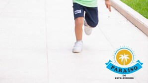 A child running on a pathway with a blue building and greenery in the background. - Paraíso do Estaleirinho - Baln Camboriú (Balneário Camboriú)