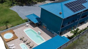 A building with a rooftop pool, solar panels, and a covered outdoor area. - Paraíso do Estaleirinho - Baln Camboriú (Balneário Camboriú)