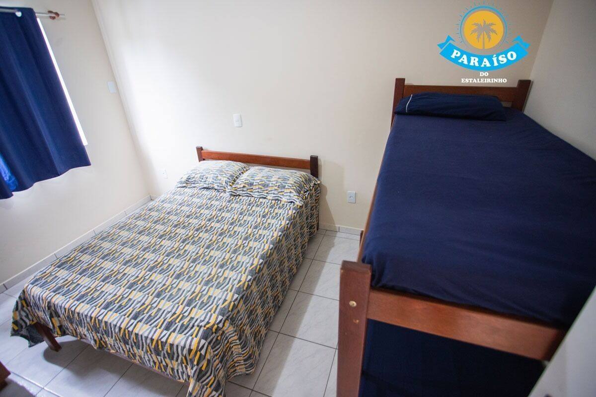 A small, single-bed room with a patterned bedspread and a plain blue bedspread.