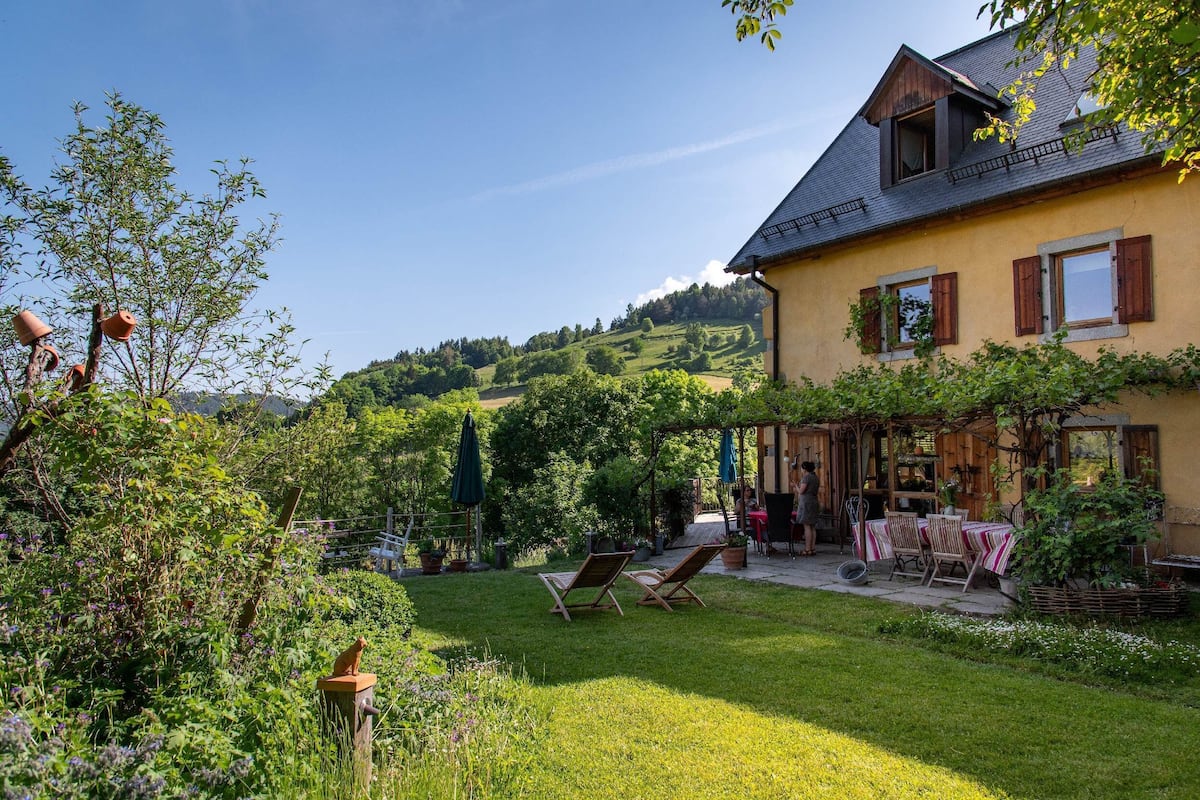 Ein Haus mit Garten, einer Terrasse mit Gartenmöbeln und Blick auf die Hügel.