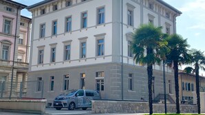 A multi-story building with a classic architectural style, featuring a balcony on the second floor and a parked vehicle in front. - Residenza Alto Garda (Riva del Garda)