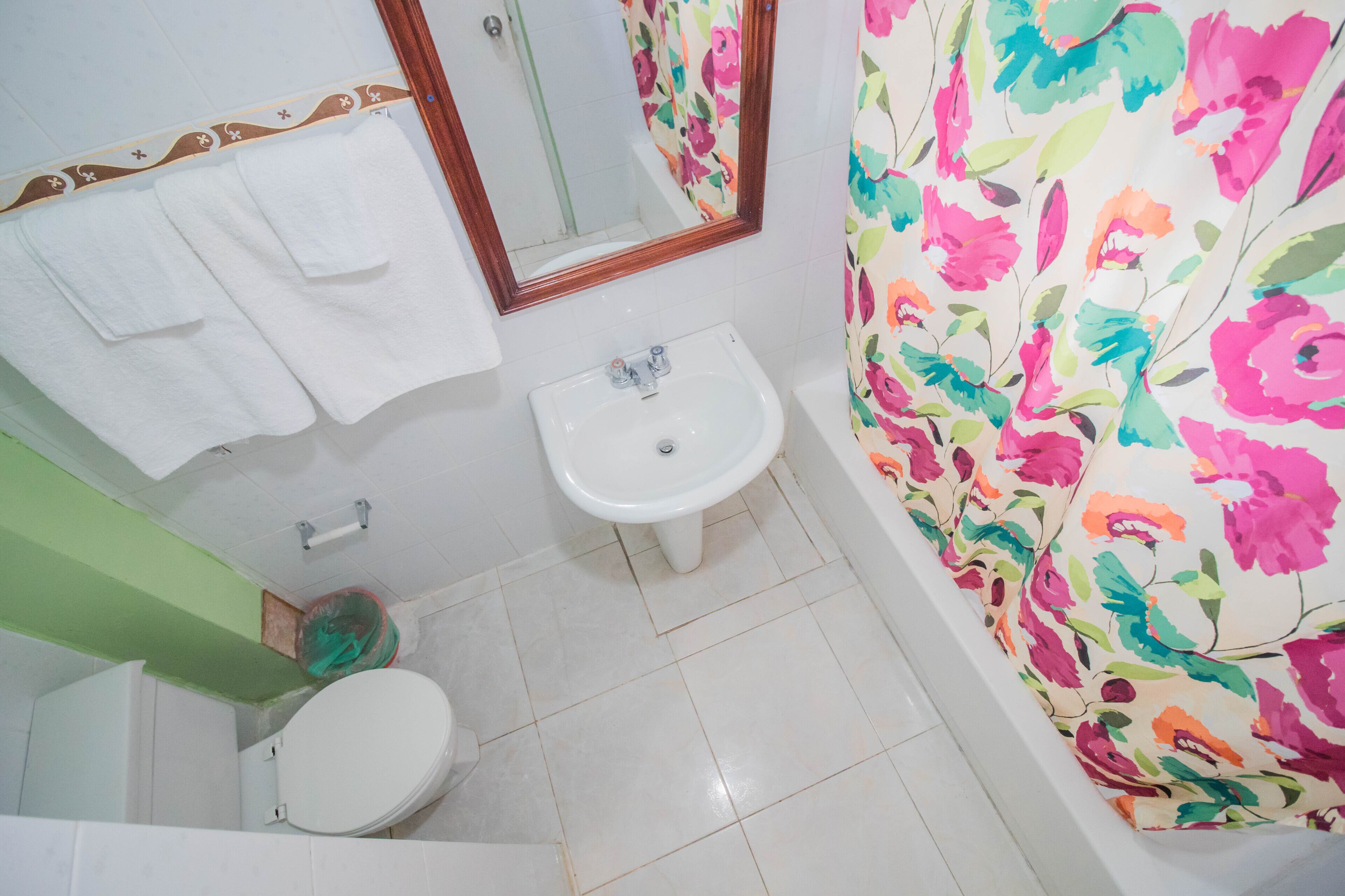 Une salle de bain comprenant des toilettes, un lavabo et un espace douche.
