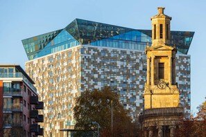 A modern building with a glass facade and a classical clock tower. - Birmingham Garnet, 3 Bedroom Apartment (Birmingham)