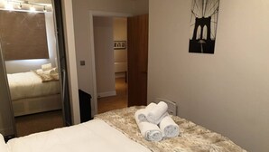 A hotel room with a bed, a fur throw, and rolled towels on the bed. - Birmingham Garnet, 3 Bedroom Apartment (Birmingham)
