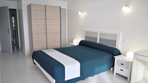 A modern bedroom with a bed, bedside tables, and a wardrobe. - T3 in the heart of the city, on the waterfront, QUIET, Owners nearby (Le Lavandou)