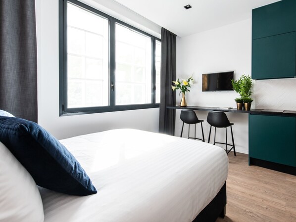 Ropa de cama de alta calidad y caja de seguridad en la habitación 