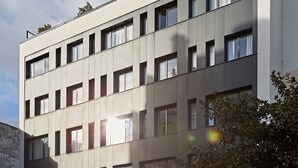 A modern building with a flat roof, multiple windows, and a sign reading "YAYS".