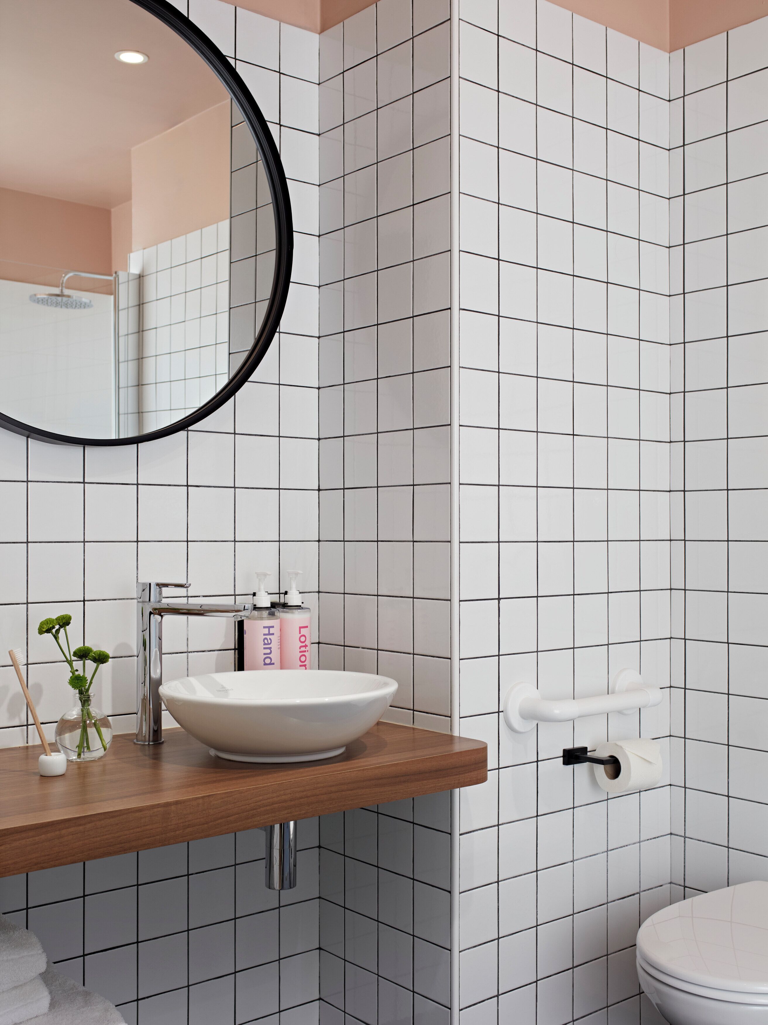 Une salle de bain avec un lavabo blanc, un miroir et des toilettes.