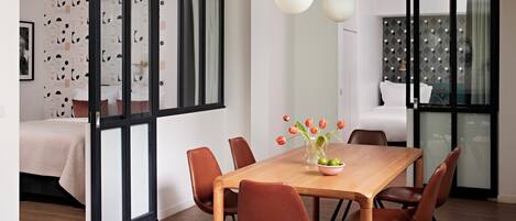 A modern dining area with a wooden table, brown chairs, and a vase with tulips.