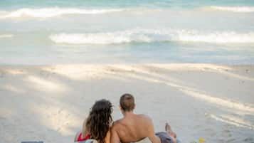 Na praia, espreguiçadeiras, toalhas de praia