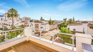 A balcony with a view of a residential area, including houses and palm trees. - Villa Catalina (Nerja)
