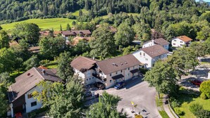 A residential area with houses surrounded by greenery and a mountain in the background. - Pension Freiheit (Pfronten)