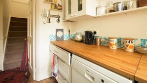 Una cocina con encimera de madera, cafetera y hervidor.