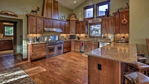 Una cocina amplia con gabinetes de madera, encimeras de granito y una isla grande.