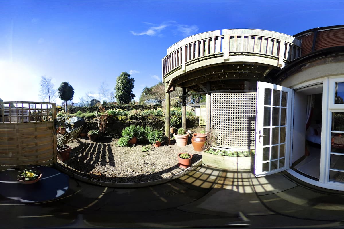 A garden with a variety of potted plants and a small seating area with a table and chairs.