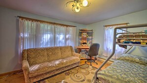A room with a sofa, bunk bed, desk, chair, and curtains. - Catskill Mtn Home w/ Deck ~ 1 Miles to Zoom Flume! (East Durham)
