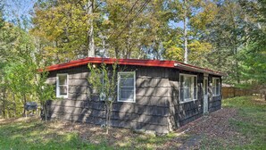 A small cabin with a red roof, surrounded by trees and a grassy yard. - Catskill Mtn Home w/ Deck ~ 1 Miles to Zoom Flume! (East Durham)