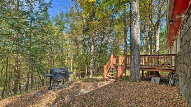 A wooden deck with a grill and a staircase leading to a cabin. - Catskill Mtn Home w/ Deck ~ 1 Miles to Zoom Flume! (East Durham)
