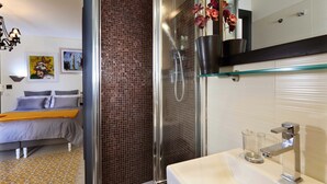 Une salle de bain moderne avec une douche à parois de verre, un lavabo blanc et un miroir au-dessus.