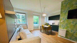 A modern apartment with a living room, dining area, and kitchen. - Green view … green in the city  (Bolzano)