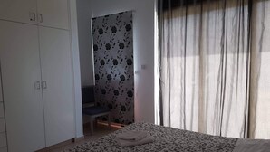 Un dormitorio con cama, armario y zona de ducha.
