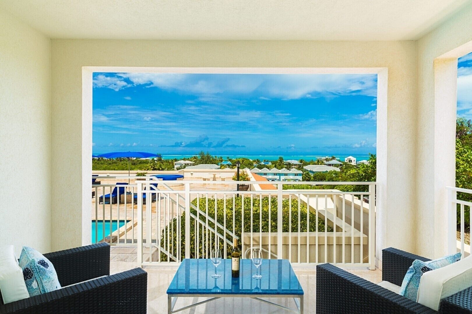 Uma varanda com vista para o oceano e uma piscina.