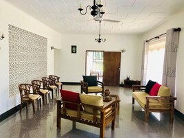 A spacious room with wooden furniture, a chandelier, and a patterned wall.