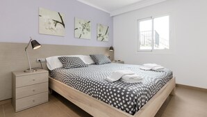 Una camera da letto con un letto, comodini e opere d'arte appese al muro.