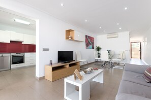 Enjoy a spacious living area with a flat-screen TV, comfortable sofa, and minimalist coffee table.