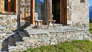 A stone building with a wooden porch, a large window, and a satellite dish. - Rustico Andrea by Interhome (Castro)