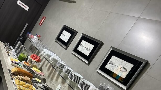 A buffet setup with various food items and a coffee station. - Grande Hotel (Gurupi)
