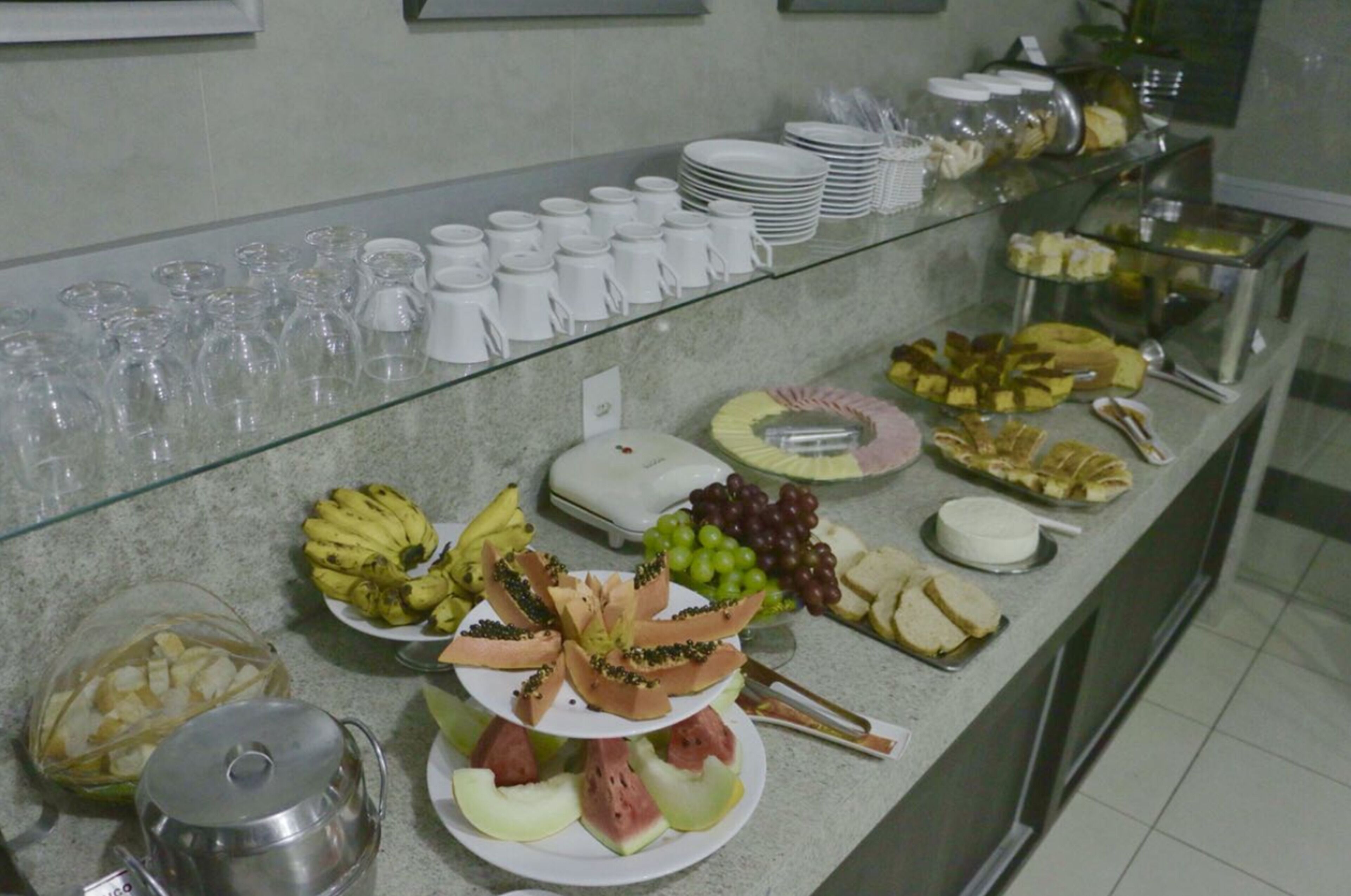 Un bufé con diferentes tipos de comida y cristalería.