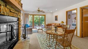 A living room with a fireplace, a dining table, and a sofa.