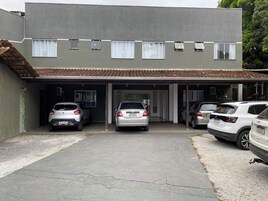 Un edificio de dos pisos con garaje cubierto para cuatro coches.